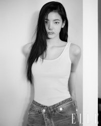 a black and white photo of a woman in jeans and a tank top